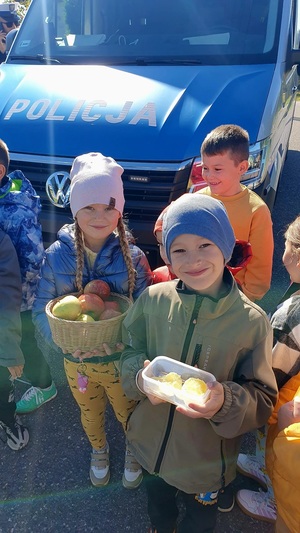 Uczniowie Szkoły Podstawowej w Wysokiej pozują do zdjęcia z jabłkami i cytrynami