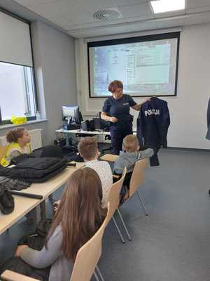 policjantka prezentuje uczniom mundur policyjny ćwiczebny