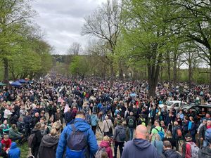 Tłum pielgrzymów idących alejką. W tle drzewa.