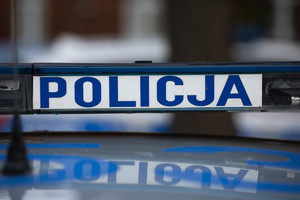 Sygnały świetlne i dźwiękowe na dachu pojazdu. Na białym tle niebieski napis Policja, po prawej i po lewej stronie światła koloru niebieskiego.