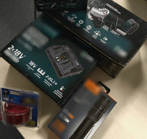 Odzyskane elektronarzędzia w tym ładowarki, szlifierka i latarka. Przedmioty są w pudełkach.