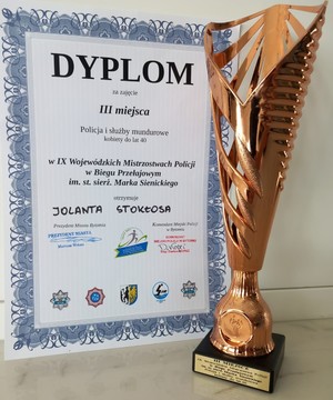 Na zdjęciu po lewej stronie dyplom, a po prawej puchar za zajęcie trzeciego miejsca w wojewódzkich biegach przełajowych.