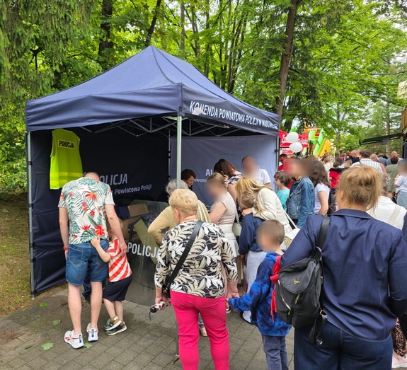 Tłum ludzi wokół namiotu koloru granatowego z napisem Komenda Powiatowa Policji w Wadowicach.
