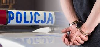 Po lewej stronie na białym tle niebieski napis Policja, po prawej dłonie trzymane z tyłu, na których są założone policyjne kajdanki