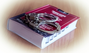 Kodeks karny na którym są położone policyjne kajdanki