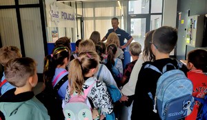 W recepcji budynku wadowickiej komendy stoi grupa dzieci, są tyłem, przed nimi policjant