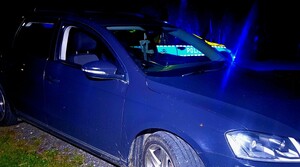 Samochód osobowy, za nim oznakowany radiowóz