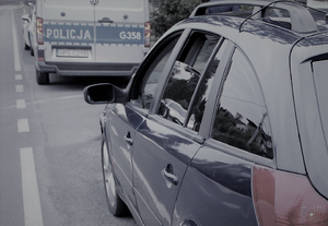 Po prawej stronie samochód osobowy, a przed nim radiowóz