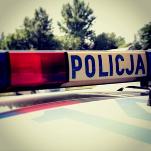 Sygnały świetlne i dźwiękowe na dachu pojazdu. Po lewej stronie światła koloru czerwonego, po prawej na białym tle niebieski napis Policja