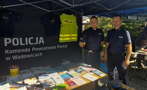 Dwóch policjantów obok stolika z ulotkami.