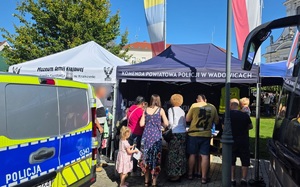 Namiot z napisem Komenda Powiatowa Policji w Wadowicach  przy którym są ludzie.