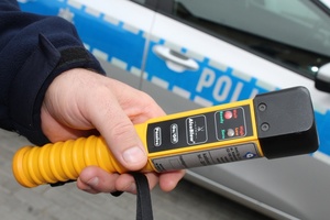 Na tle radiowozu policyjny alkomat