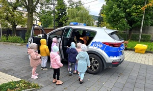 Dzieci oglądające policyjny radiowóz.