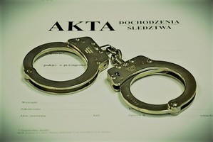 Policyjne kajdanki położone na aktach sprawy