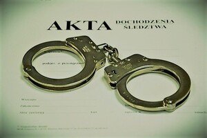 Policyjne kajdanki położone na aktach sprawy