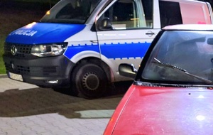 Oznakowany radiowóz i fragment osobowego samochodu