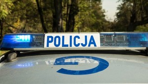 Sygnały świetlne i dźwiękowe na dachu pojazdu. Na białym tle niebieski napis Policja, po lewej i prawej stronie światła koloru niebieskiego