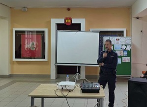 Policjant trzymający w ręku mikrofon