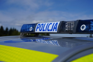 Sygnały świetlne i dźwiękowe na dachu pojazdu. Na białym tle niebieski napis Policja, po prawej i lewej stronie świata koloru niebieskiego.