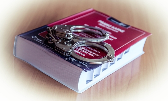 Kodeks karny i położone na nim policyjne kajdanki