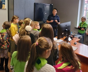 Na zdjęciu grupa dzieci i umundurowana policjantka.