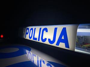 Na białym tle niebieski napis Policja. Czarne tło.