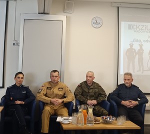 Na fotelach od lewej siedzi policjantka, strażak, żołnierz i strażnik miejski.