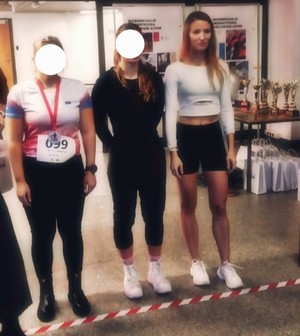 Trzy kobiety, laureatki biegu po schodach. W tle puchary na stoliku.