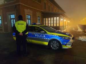 Na terenie PKP radiowóz i policjant w kamizelce odblaskowej