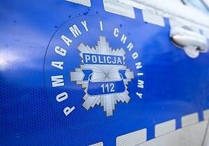 Na niebieskim tle odznaka policyjna z napisem Policja 112. Wokoło napis Pomagamy i Chronimy.