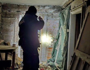 Umundurowany policjant sprawdzający pomieszczenia pustostanu