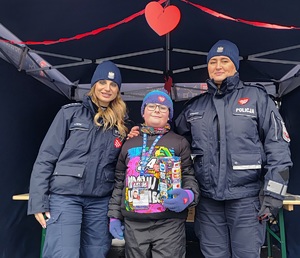 Dwie policjantki i chłopiec z puszką  wośp