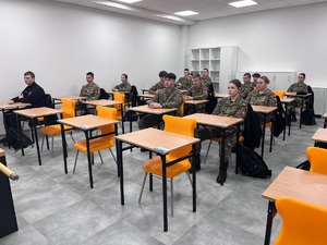 Uczniowie w mundurach siedzący w szkolnych ławkach