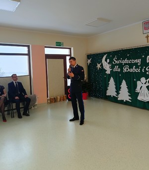 Umundurowany policjant trzymający w ręku mikrofon