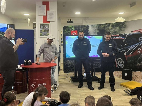 Na zdjęciu dwóch policjantów oraz dwóch mężczyzn w stroju cywilnym. Jeden trzyma aparat.