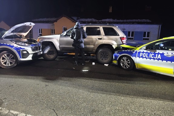 Na zdjęciu trzy uszkodzone samochody, dwa radiowozy i jeep.