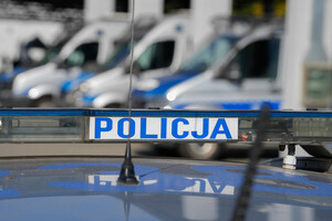 Napis Policja, w tle radiowozy