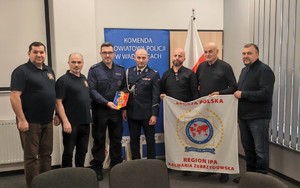 Na zdjęciu dwóch umundurowanych policjantów i pięciu mężczyzn w stroju cywilnym.