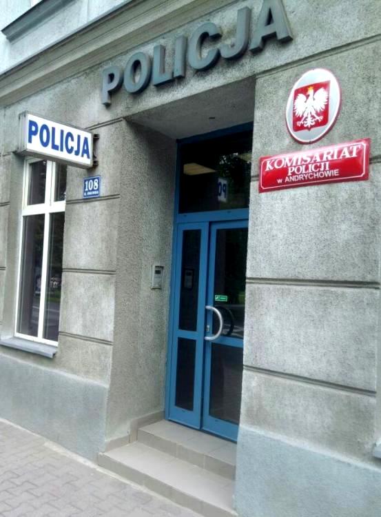 Drzwi wejściowe do komisariatu. Nad nimi napis Policja, po prawej stronie Godło Polski i tabliczka z napisem Komisariat Policji w Andrychowie, a po lewej nazwa i numer ulicy oraz napis Policja