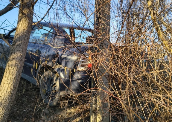 Samochód osobowy koloru granatowego, który uderzył w słup energetyczny