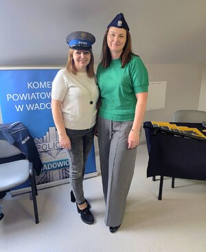 Dwie kobiety w strojach cywilnych, na głowie mają czapki policyjne