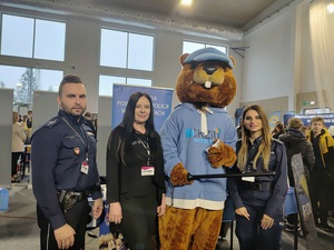 Maskotka wiewiórki oraz kobieta w stroju cywilnym oraz policjantka i policjant.