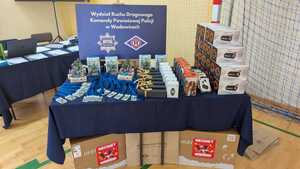 Na stoliki poukładane nagrody i medale. W tle baner.