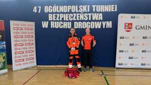 Na tle banerów dwóch ratowników medycznych.