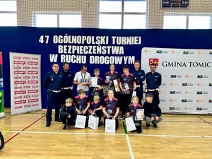 Na zdjęciu czterech policjantów oraz grupa uczniów z medalami.