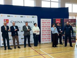 Trzech mężczyzn i dwie kobiety oraz dwóch policjantów. W  tle banery.