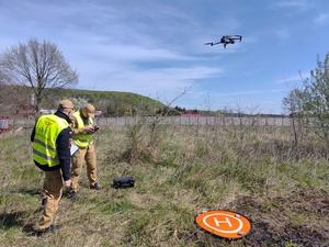 Dwóch strażaków i wzbijający się dron