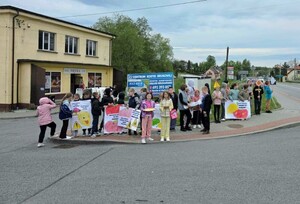 Grupa dzieci z plakatami stojących na chodniku