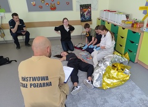 Strażak, policjant oraz drużyna udzielająca pomocy poszkodowanej
