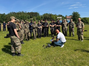 Operator drona, a wokoło uczniowie klas mundurowych